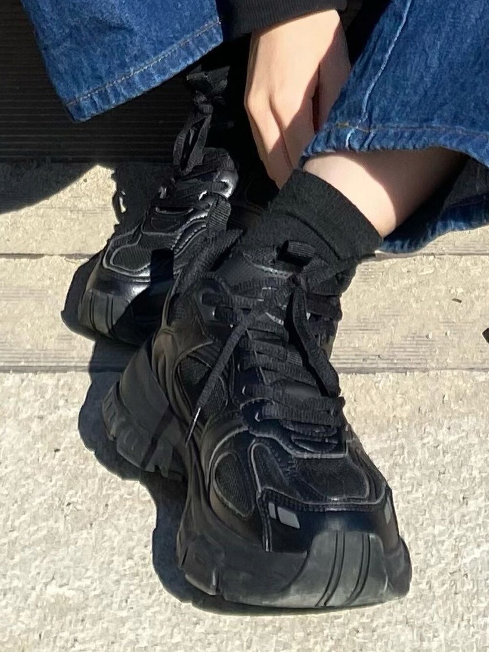 ブラック系のスニーカーを着用したレディースの秋コーディネートの4枚目の写真