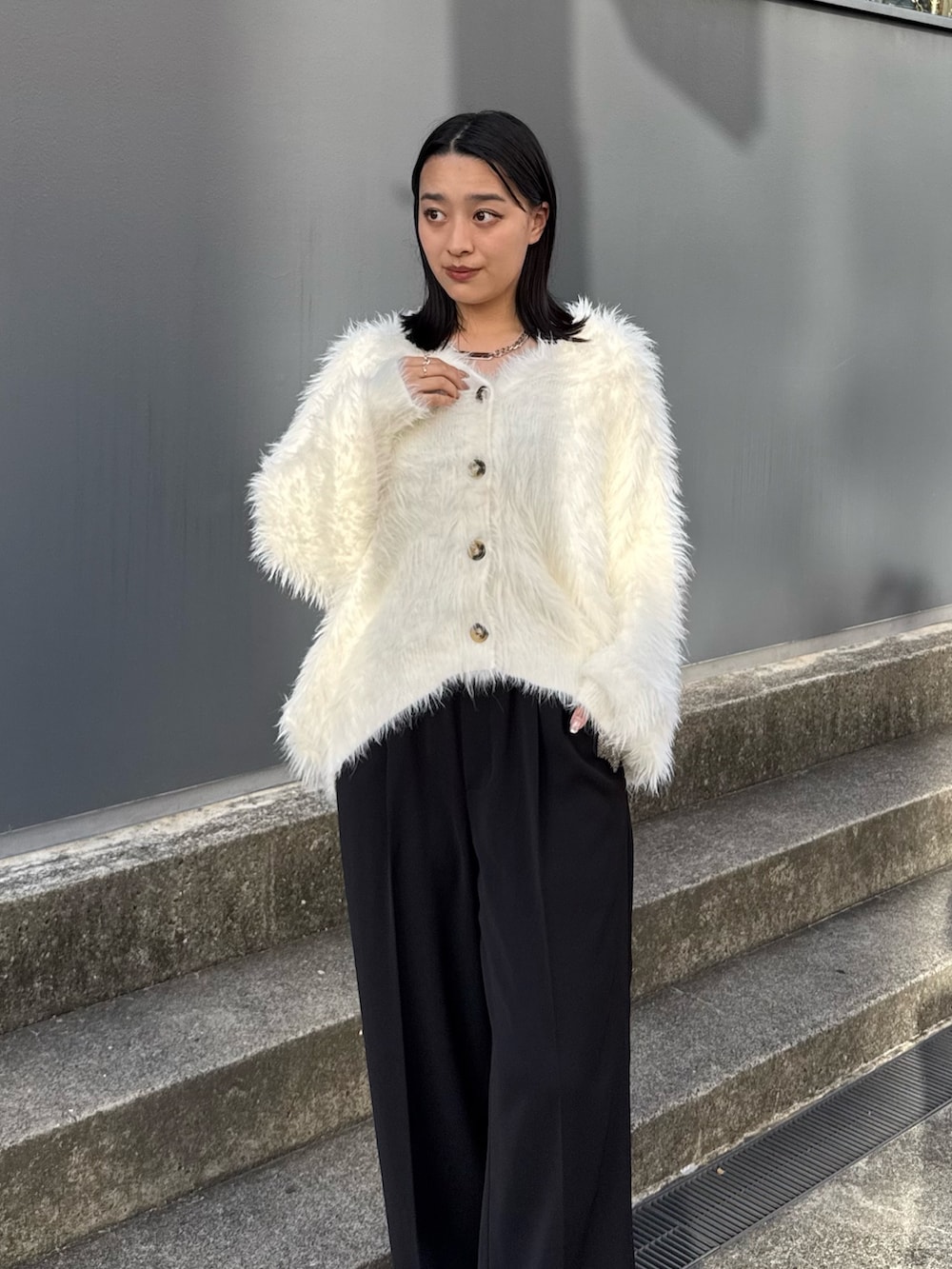 ブラック系のスラックス、ブラック系のブーツ、ホワイト系のカーディガン/ボレロを着用したレディースの夏コーディネートの3枚目の写真