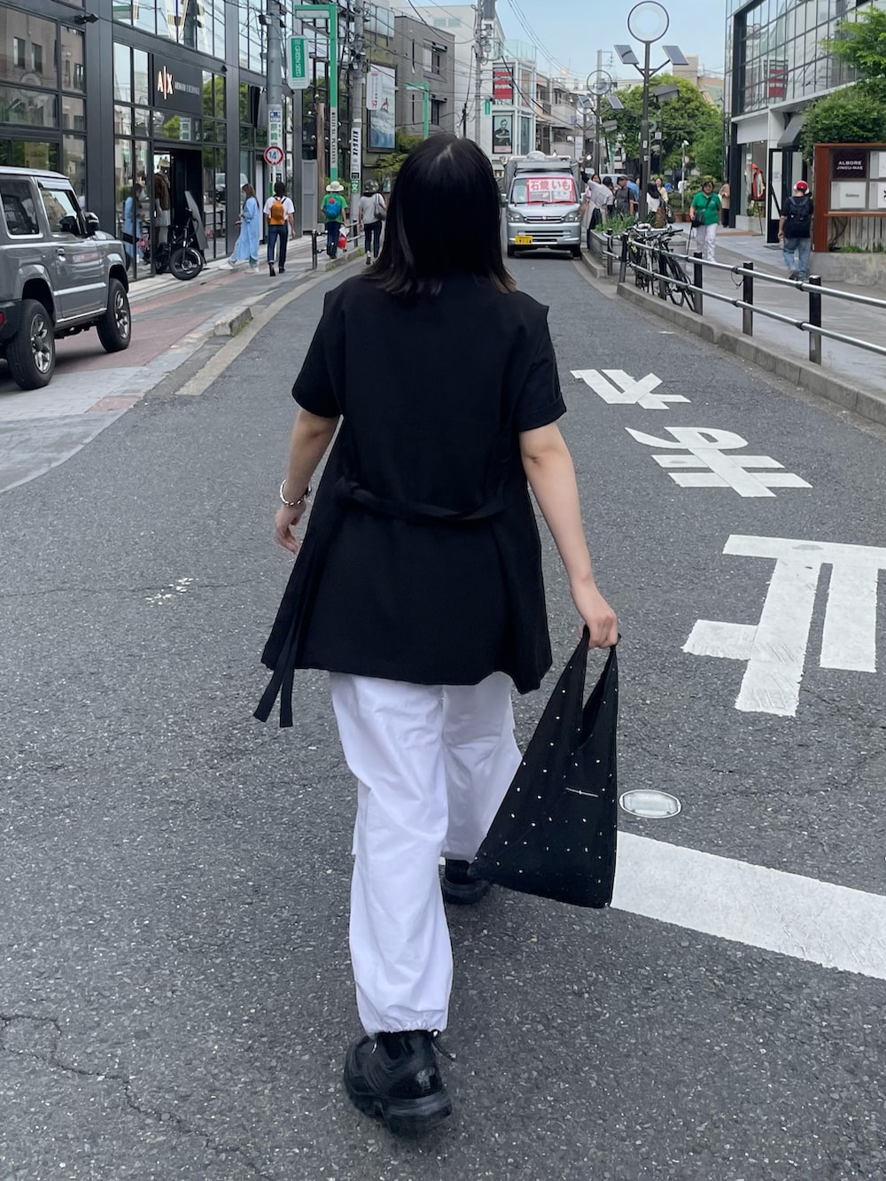 ブラック系のベスト、ホワイト系のその他パンツを着用したレディースの春コーディネートの4枚目の写真