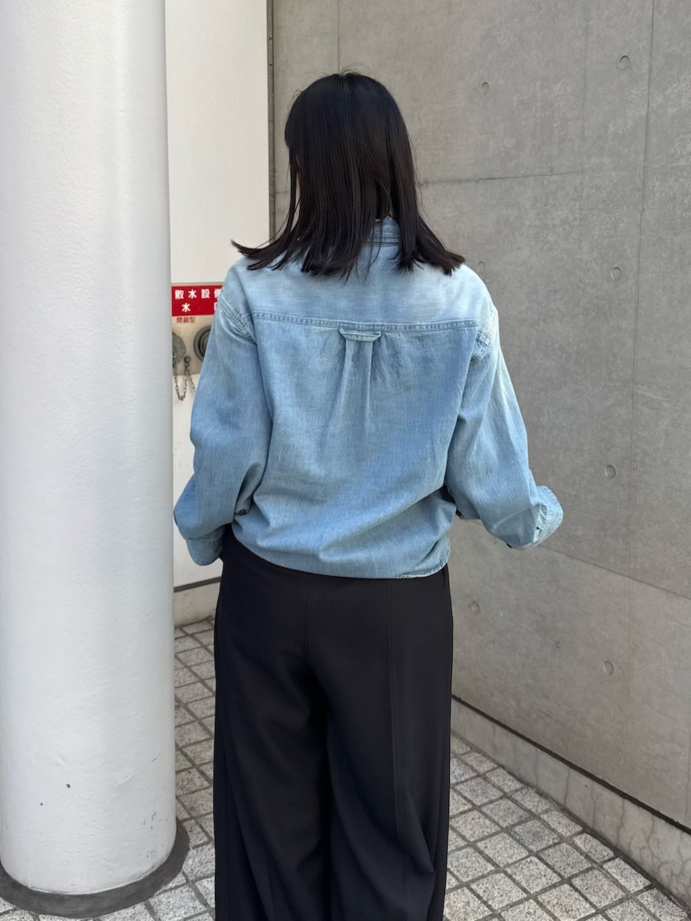 ブルー系のシャツ/ブラウス、ブラック系のスラックス、ブラック系のブーツを着用したレディースの秋コーディネートの4枚目の写真