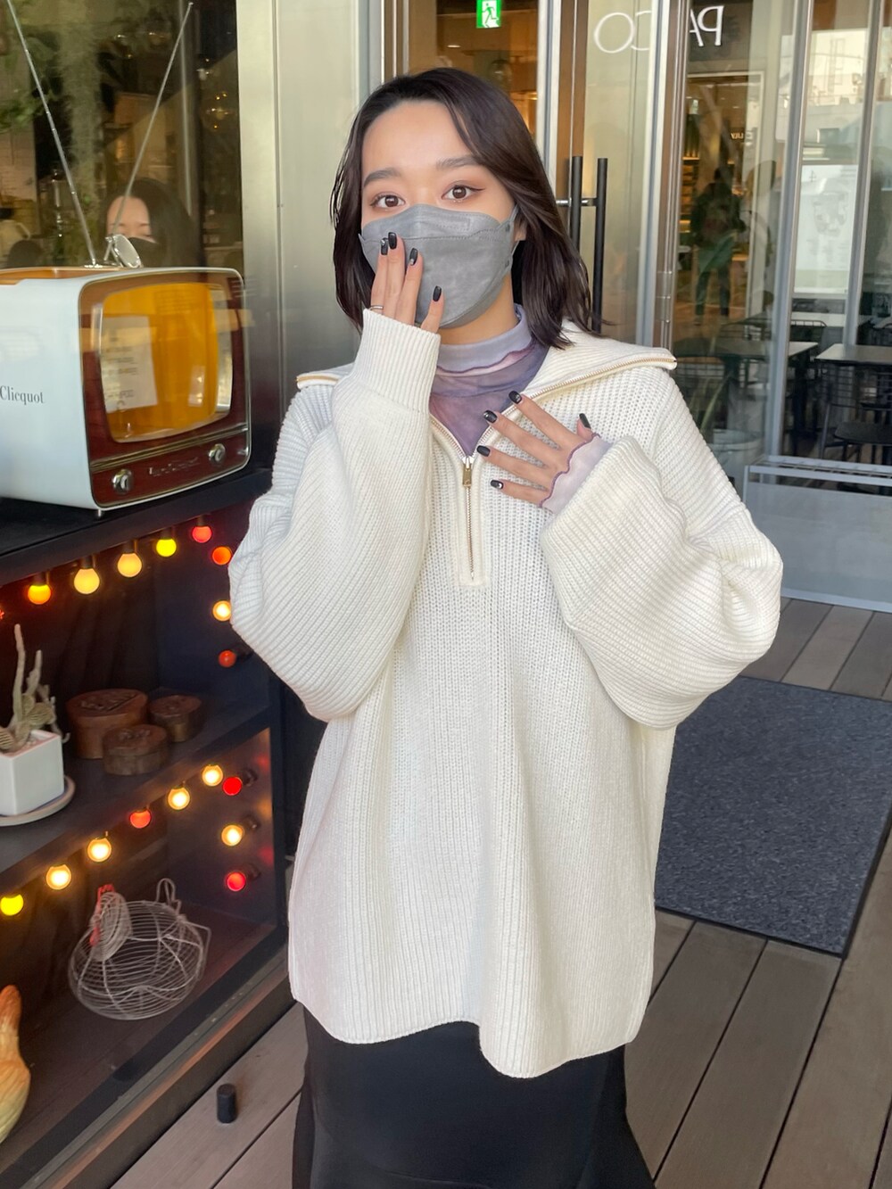 ホワイト系のニット/セーター、パープル系のTシャツ/カットソー、ブラック系のスカートを着用したレディースの冬コーディネートの4枚目の写真