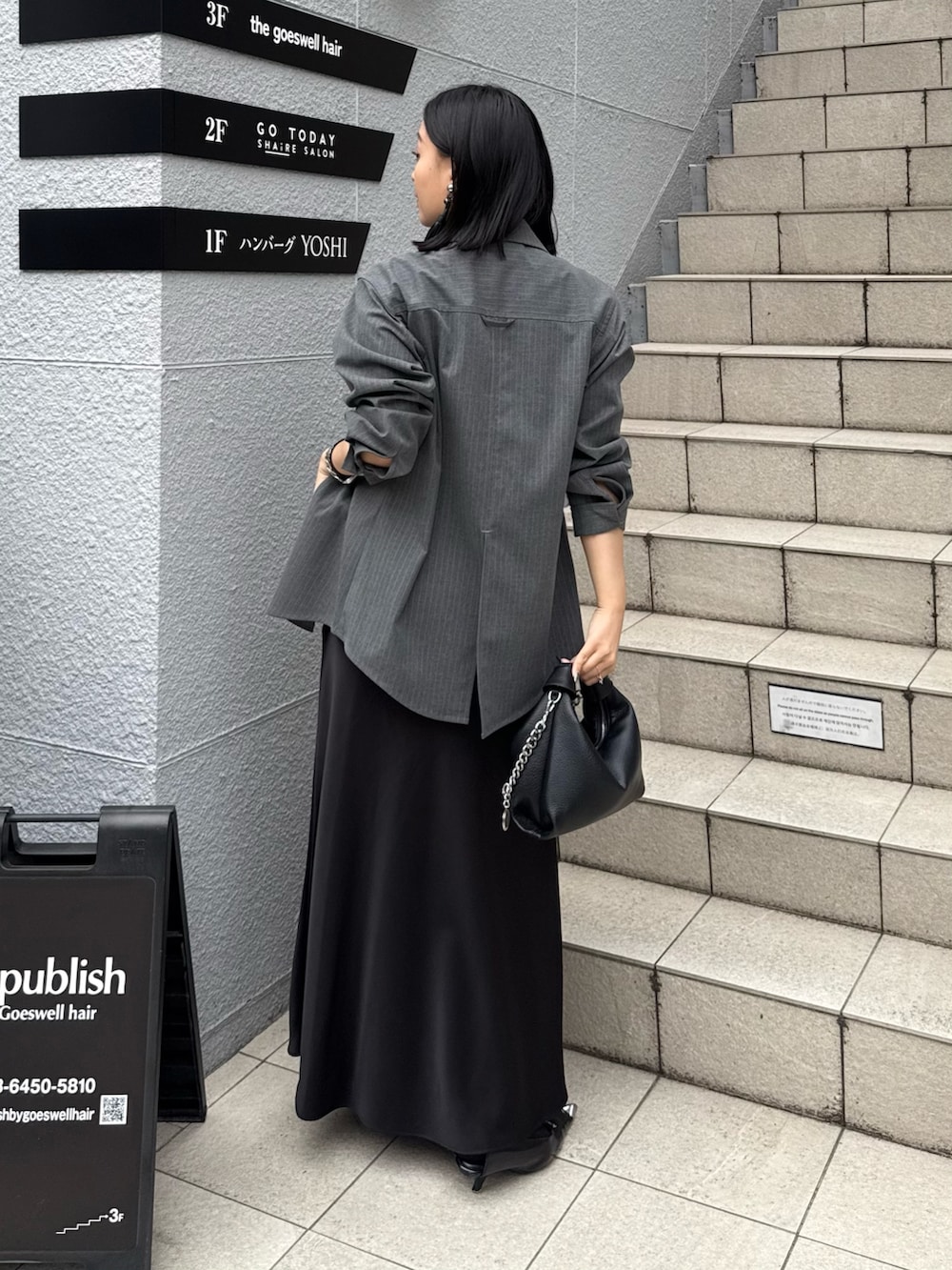 グレー系のシャツ/ブラウス、ブラック系のスカート、ブラック系のトートバッグを着用したレディースの春コーディネートの2枚目の写真