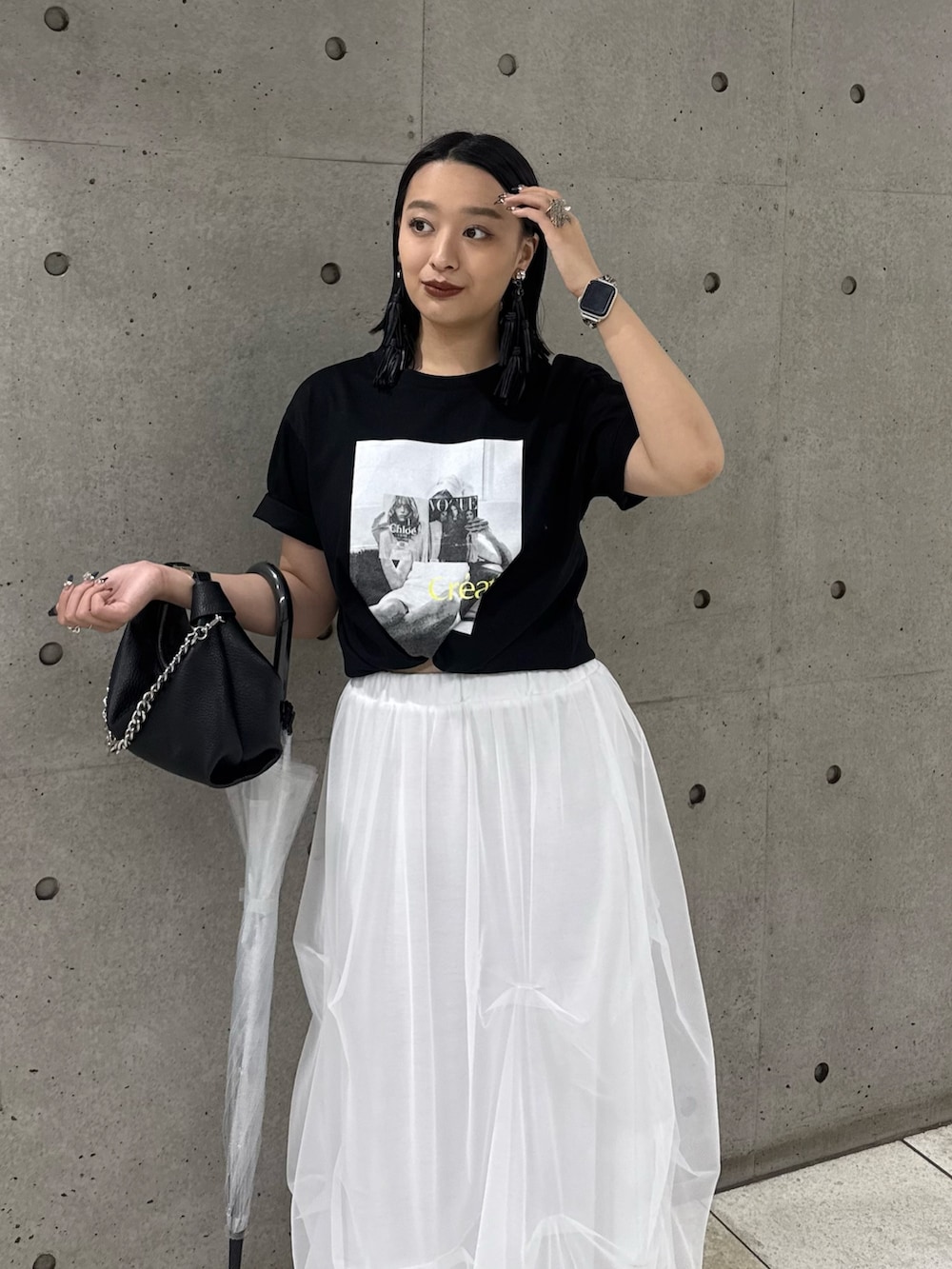ブラック系のTシャツ/カットソー、ホワイト系のスカート、ブラック系のトートバッグを着用したレディースの春コーディネートの3枚目の写真