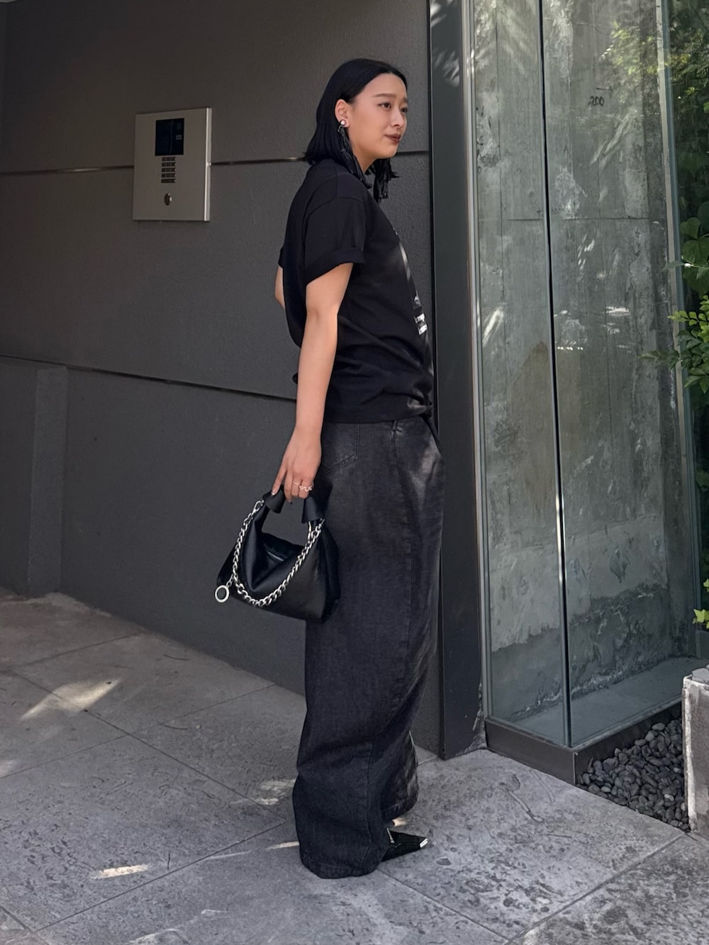 ブラック系のTシャツ/カットソー、ブラック系のデニムパンツ、ブラック系のトートバッグを着用したレディースの春コーディネートの2枚目の写真