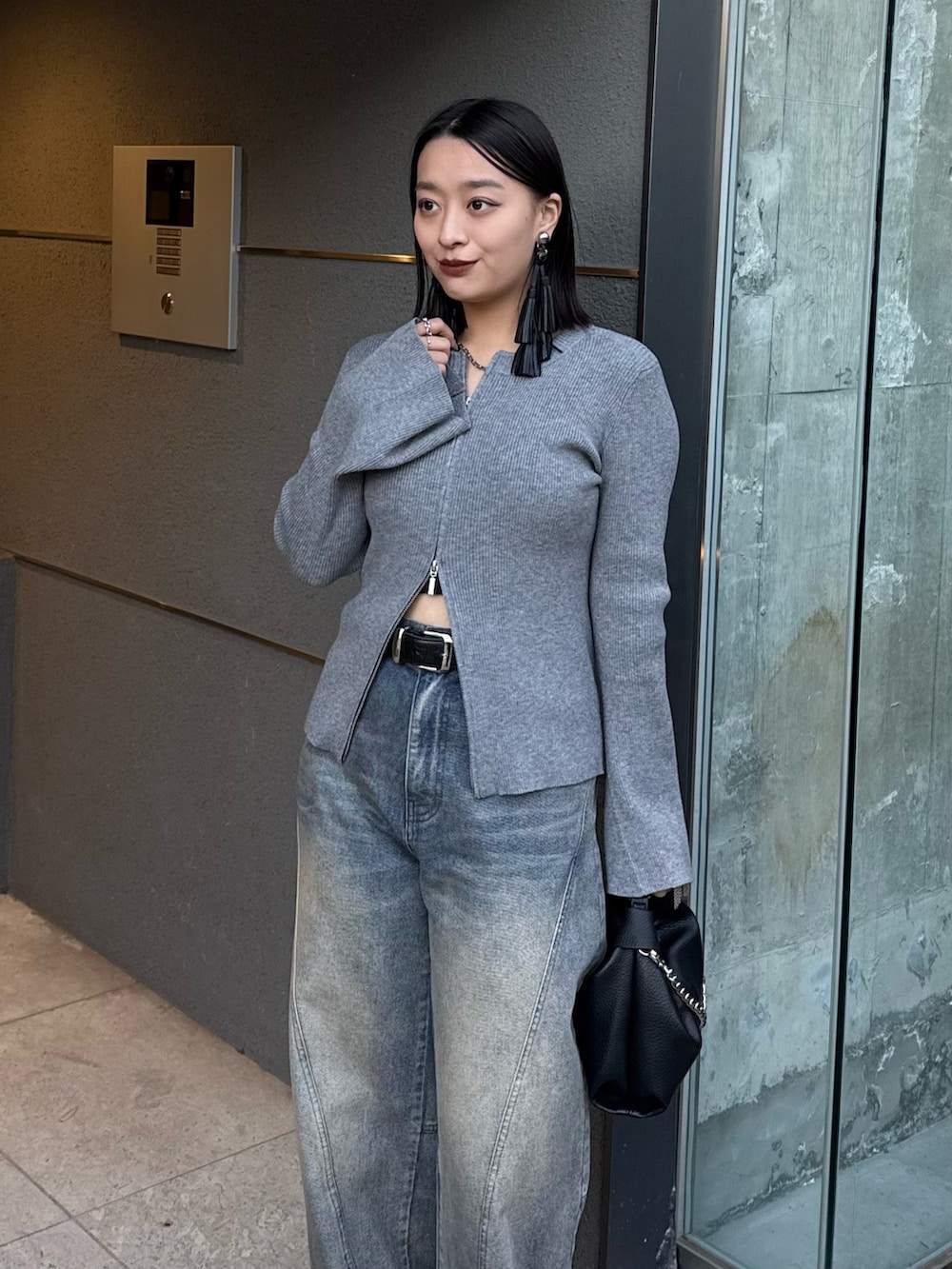 グレー系のニット/セーター、ブルー系のデニムパンツ、ブラック系のトートバッグを着用したレディースの冬コーディネートの3枚目の写真