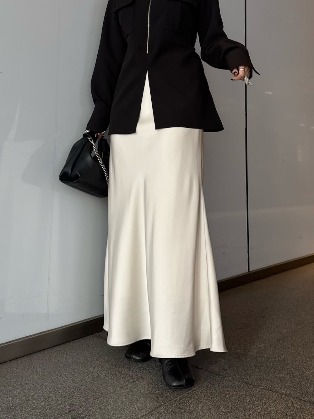 ブラック系のシャツ/ブラウス、ホワイト系のスカート、ブラック系のトートバッグを着用したレディースの春コーディネートの5枚目の写真