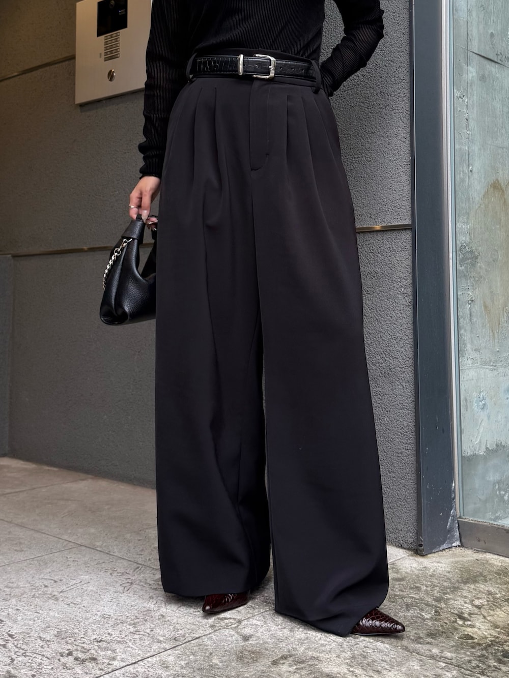 ブラック系のTシャツ/カットソー、ブラック系のスラックス、ブラック系のトートバッグを着用したレディースの秋コーディネートの5枚目の写真