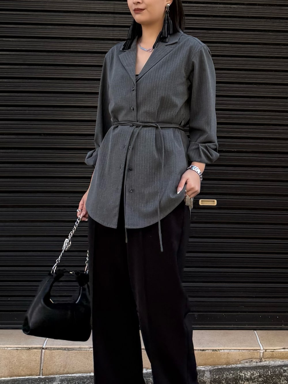 グレー系のシャツ/ブラウス、ブラック系のスラックス、ブラック系のトートバッグを着用したレディースの冬コーディネートの4枚目の写真