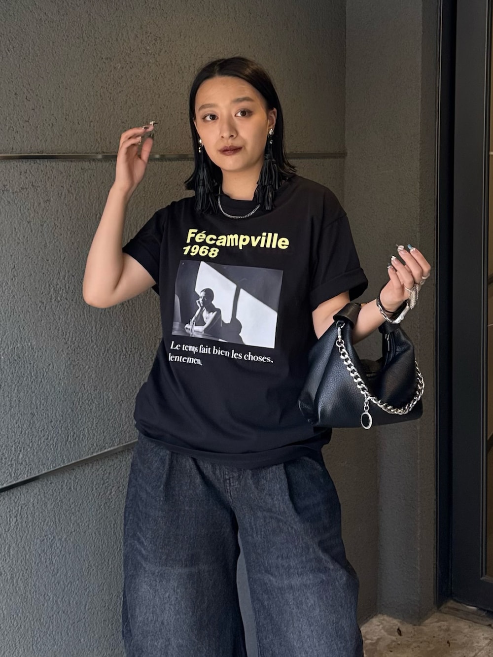 ブラック系のTシャツ/カットソー、ブラック系のデニムパンツ、ブラック系のトートバッグを着用したレディースの春コーディネートの4枚目の写真