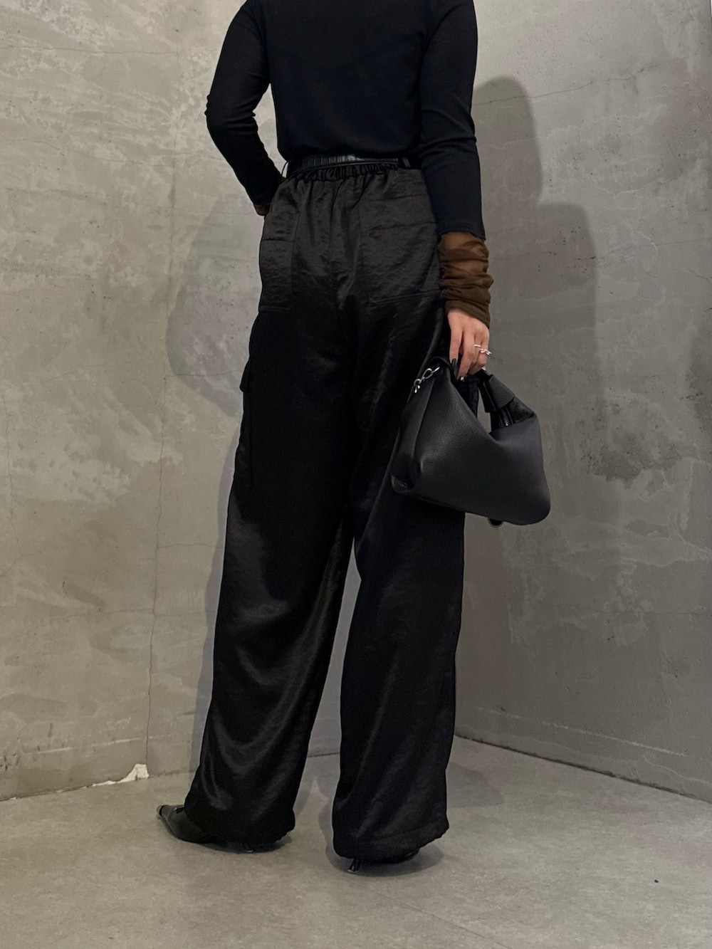 ブラック系のTシャツ/カットソー、ブラック系のカーゴパンツ、ブラック系のトートバッグを着用したレディースの冬コーディネートの7枚目の写真