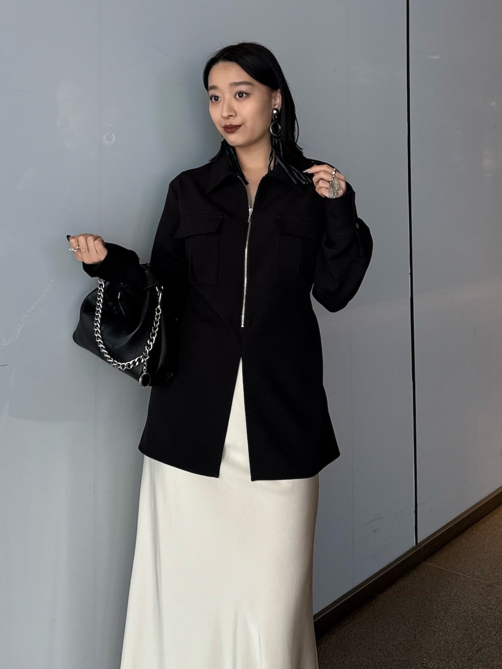 ブラック系のシャツ/ブラウス、ホワイト系のスカート、ブラック系のトートバッグを着用したレディースの春コーディネートの3枚目の写真