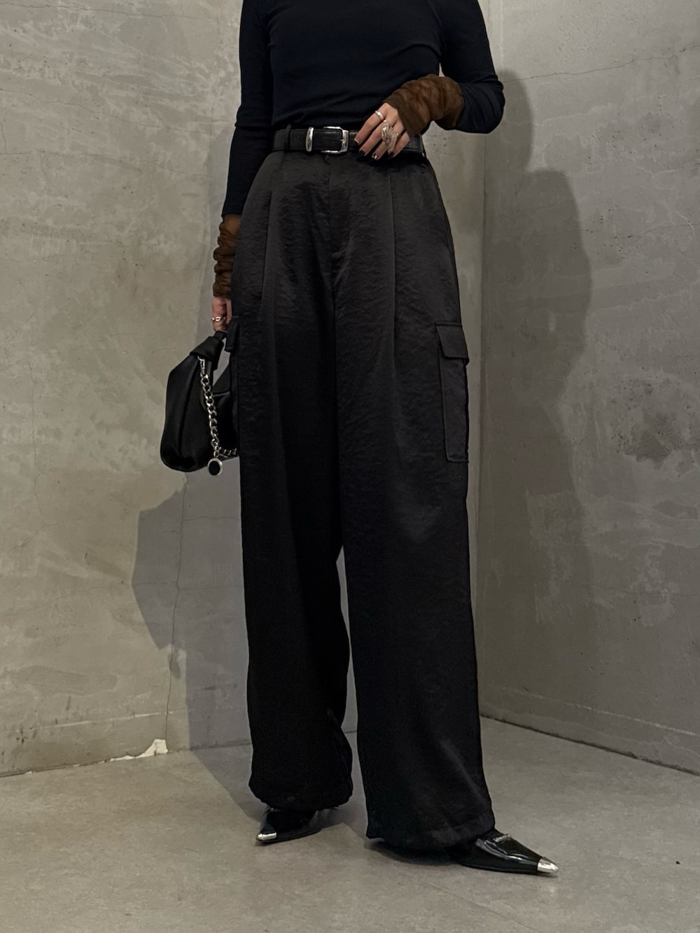 ブラック系のTシャツ/カットソー、ブラック系のカーゴパンツ、ブラック系のトートバッグを着用したレディースの冬コーディネートの6枚目の写真