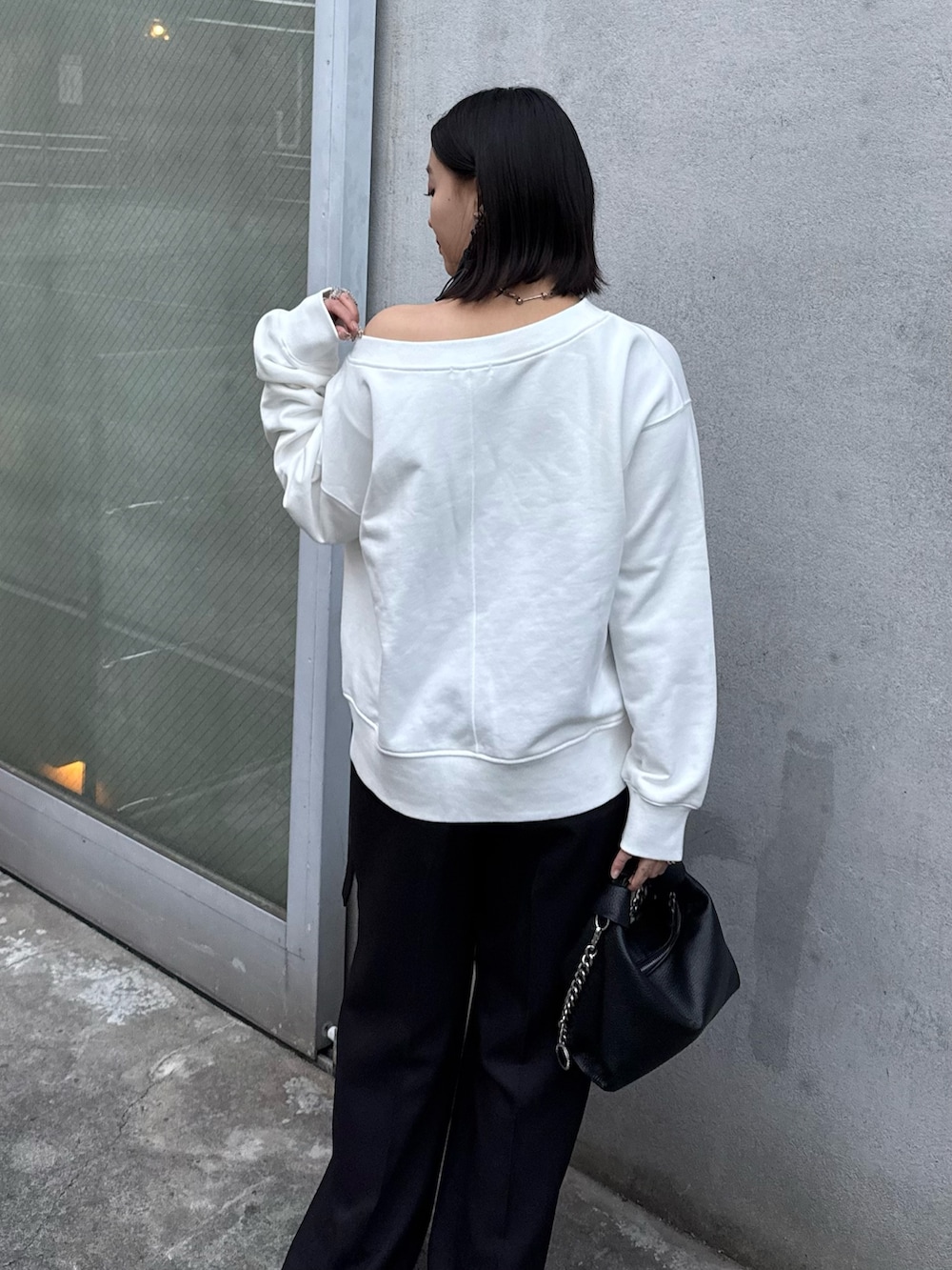 ホワイト系のTシャツ/カットソー、ブラック系のスラックス、ブラック系のトートバッグを着用したレディースの冬コーディネートの5枚目の写真