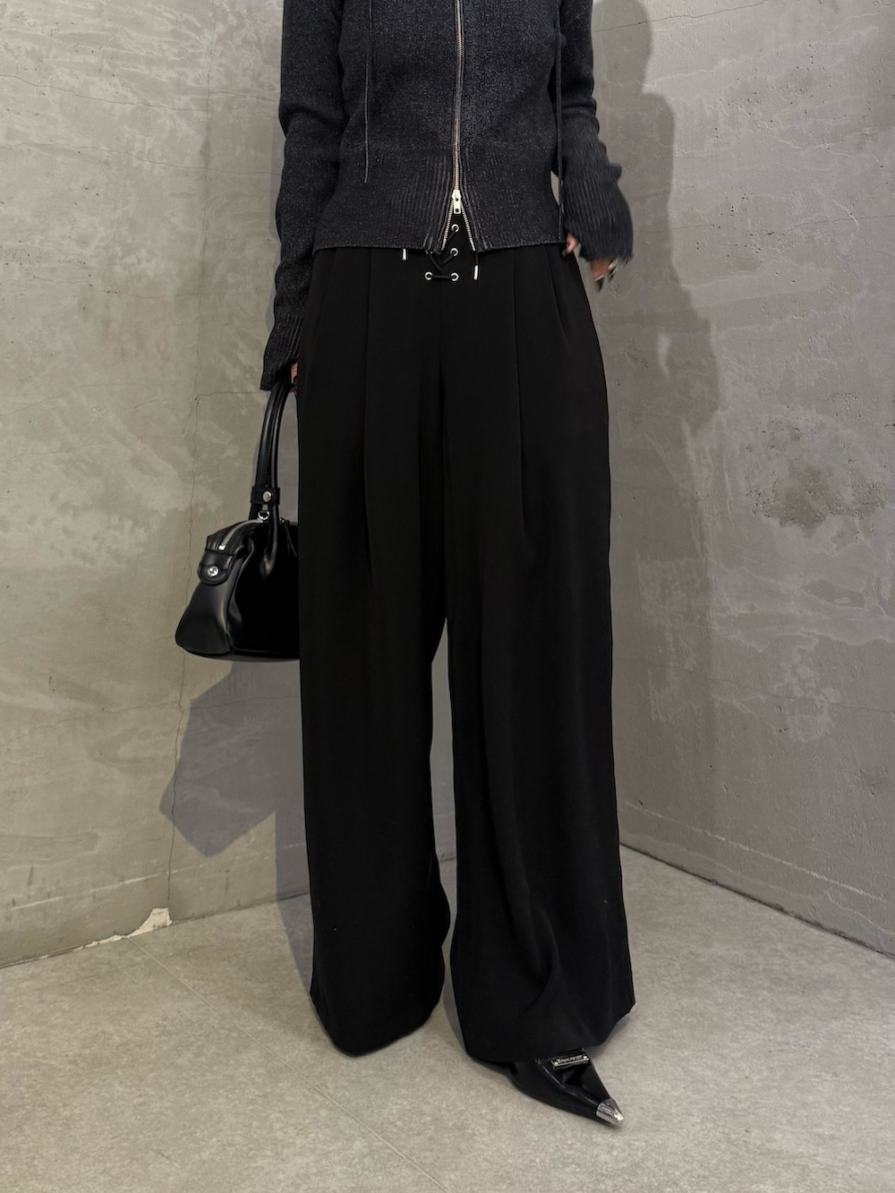 ブラック系のニット/セーター、ブラック系のスラックス、ブラック系のトートバッグを着用したレディースの冬コーディネートの5枚目の写真