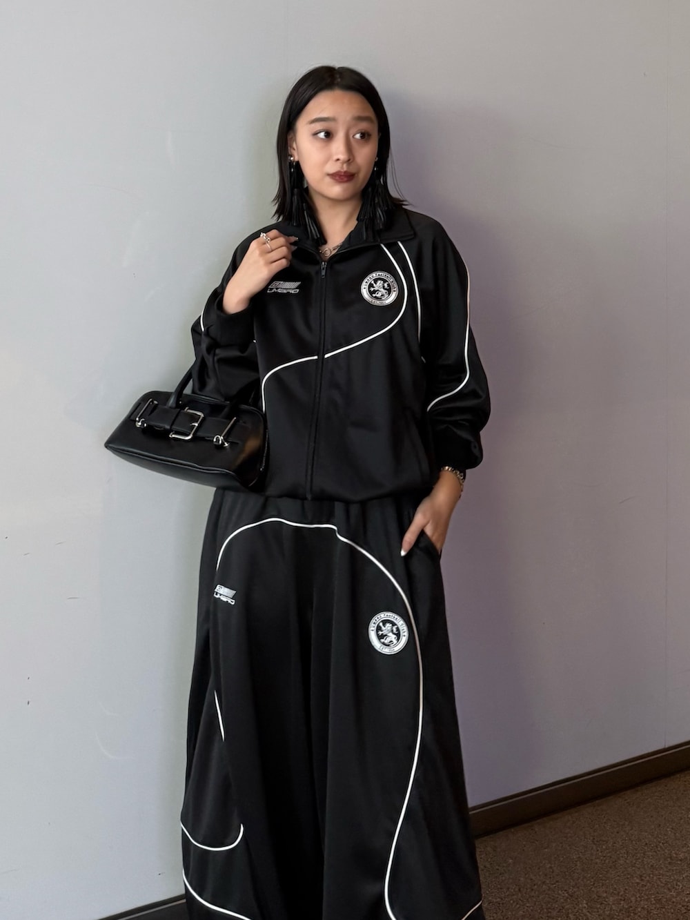 ブラック系のブルゾン、ブラック系のその他パンツ、ブラック系のショルダーバッグを着用したレディースの冬コーディネートの4枚目の写真