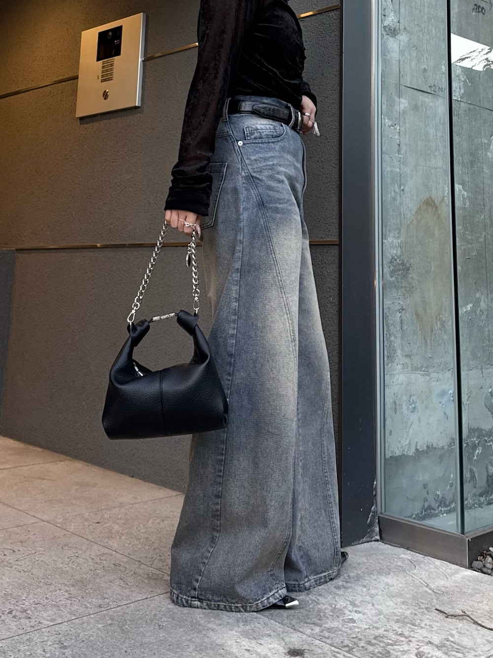 ブラック系のTシャツ/カットソー、ブルー系のデニムパンツ、ブラック系のトートバッグを着用したレディースの冬コーディネートの6枚目の写真