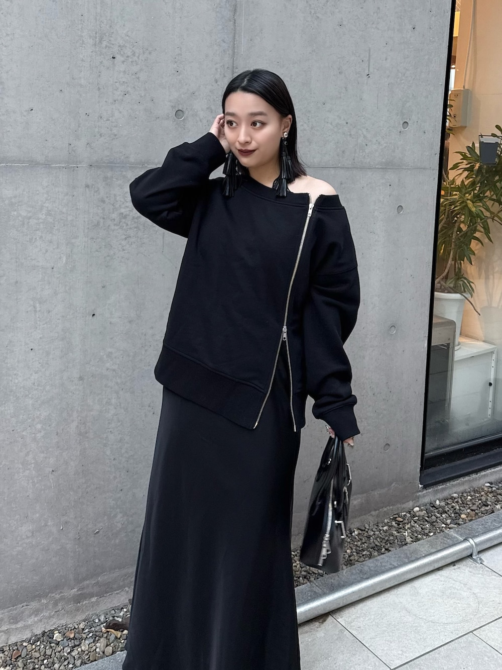 ブラック系のTシャツ/カットソー、ブラック系のスカート、ブラック系のショルダーバッグを着用したレディースの冬コーディネートの2枚目の写真