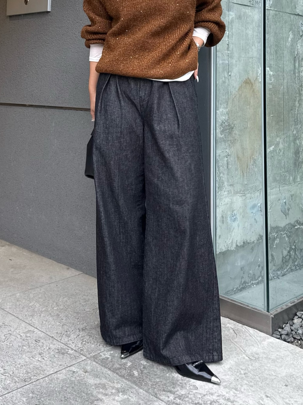 ブラウン系のニット/セーター、ブラック系のデニムパンツ、ブラック系のトートバッグを着用したレディースの秋コーディネートの4枚目の写真