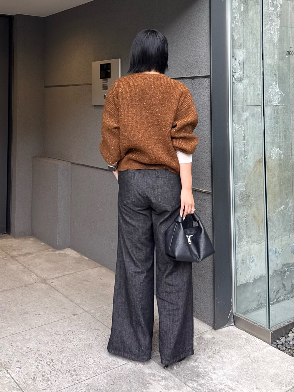 ブラウン系のニット/セーター、ブラック系のデニムパンツ、ブラック系のトートバッグを着用したレディースの秋コーディネートの2枚目の写真