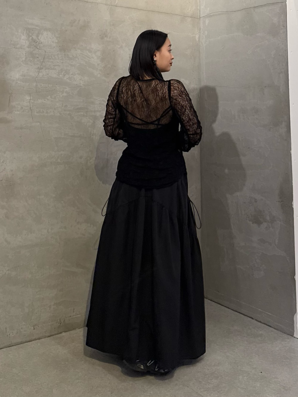 ブラック系のTシャツ/カットソー、ブラック系のスカート、ブラック系のトートバッグを着用したレディースの冬コーディネートの3枚目の写真