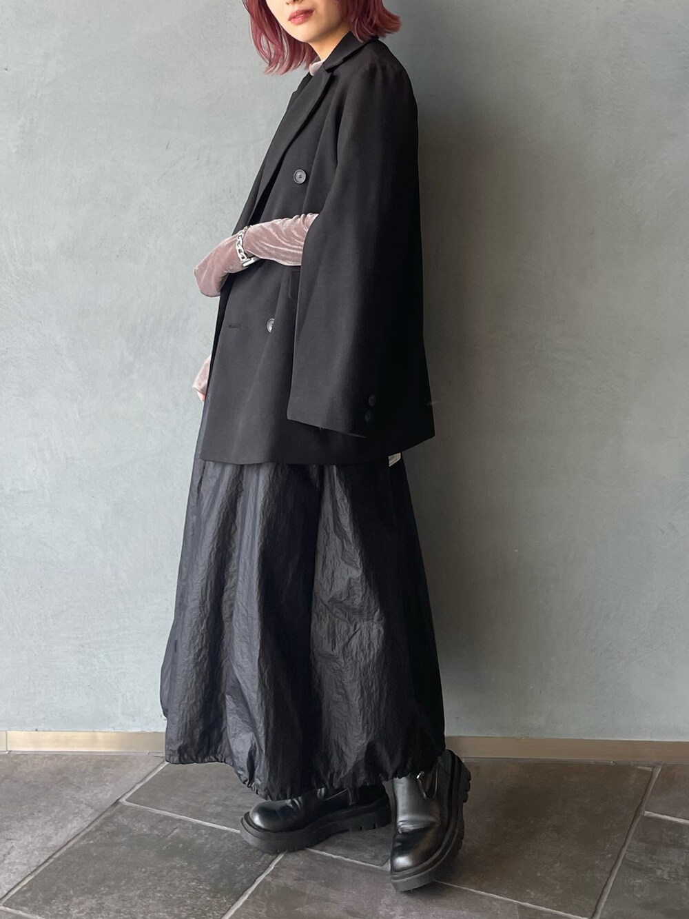 グリーン系のテーラードジャケット、ベージュ系のTシャツ/カットソー、ブラック系のスカートを着用したレディースの秋コーディネートの2枚目の写真