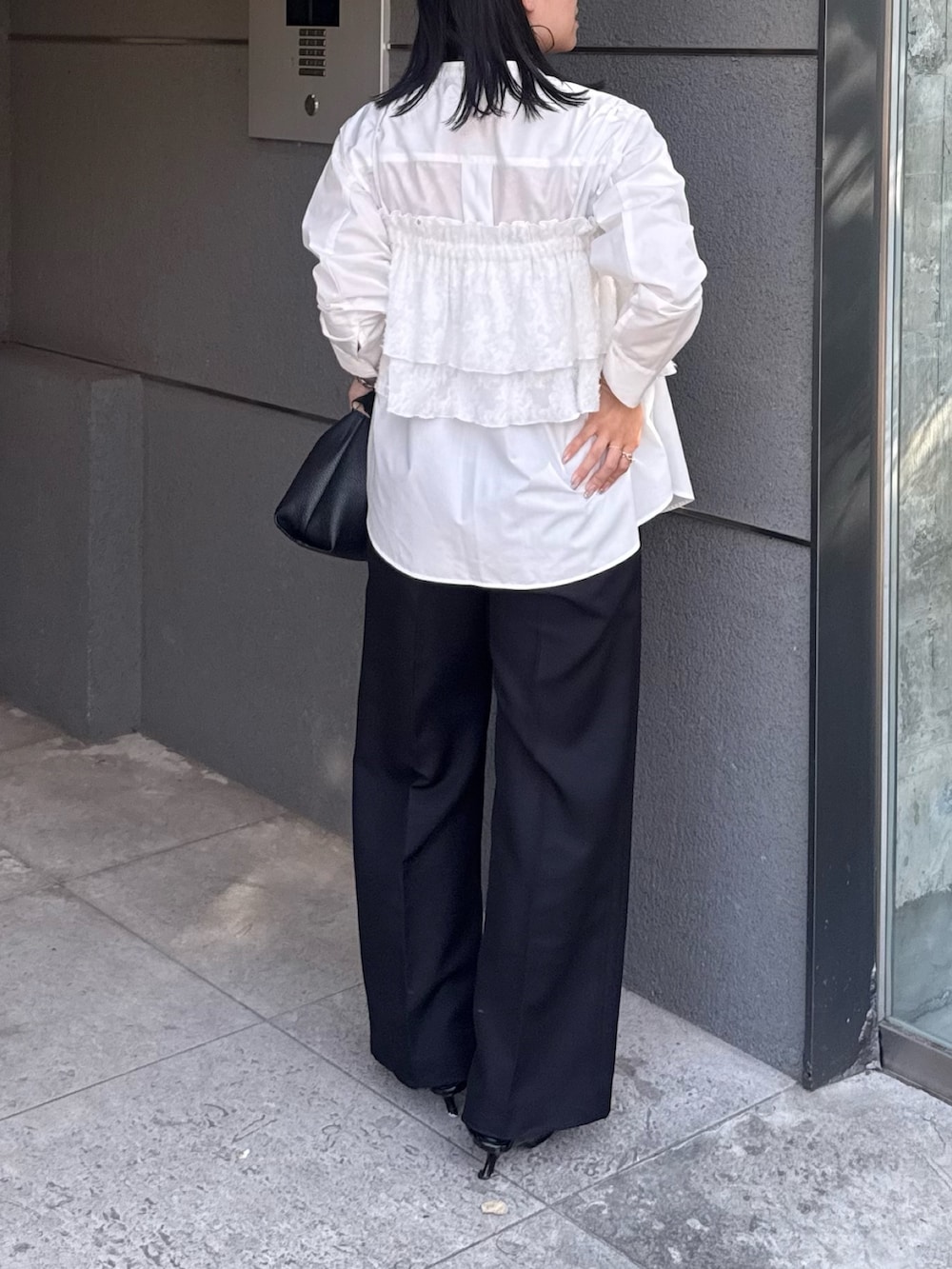 ホワイト系のシャツ/ブラウス、ブラック系のスラックス、ブラック系のベルトを着用したレディースの夏コーディネートの2枚目の写真