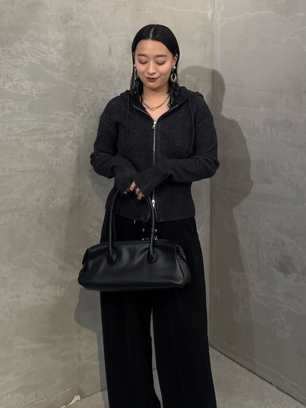 ブラック系のニット/セーター、ブラック系のスラックス、ブラック系のトートバッグを着用したレディースの冬コーディネートの3枚目の写真
