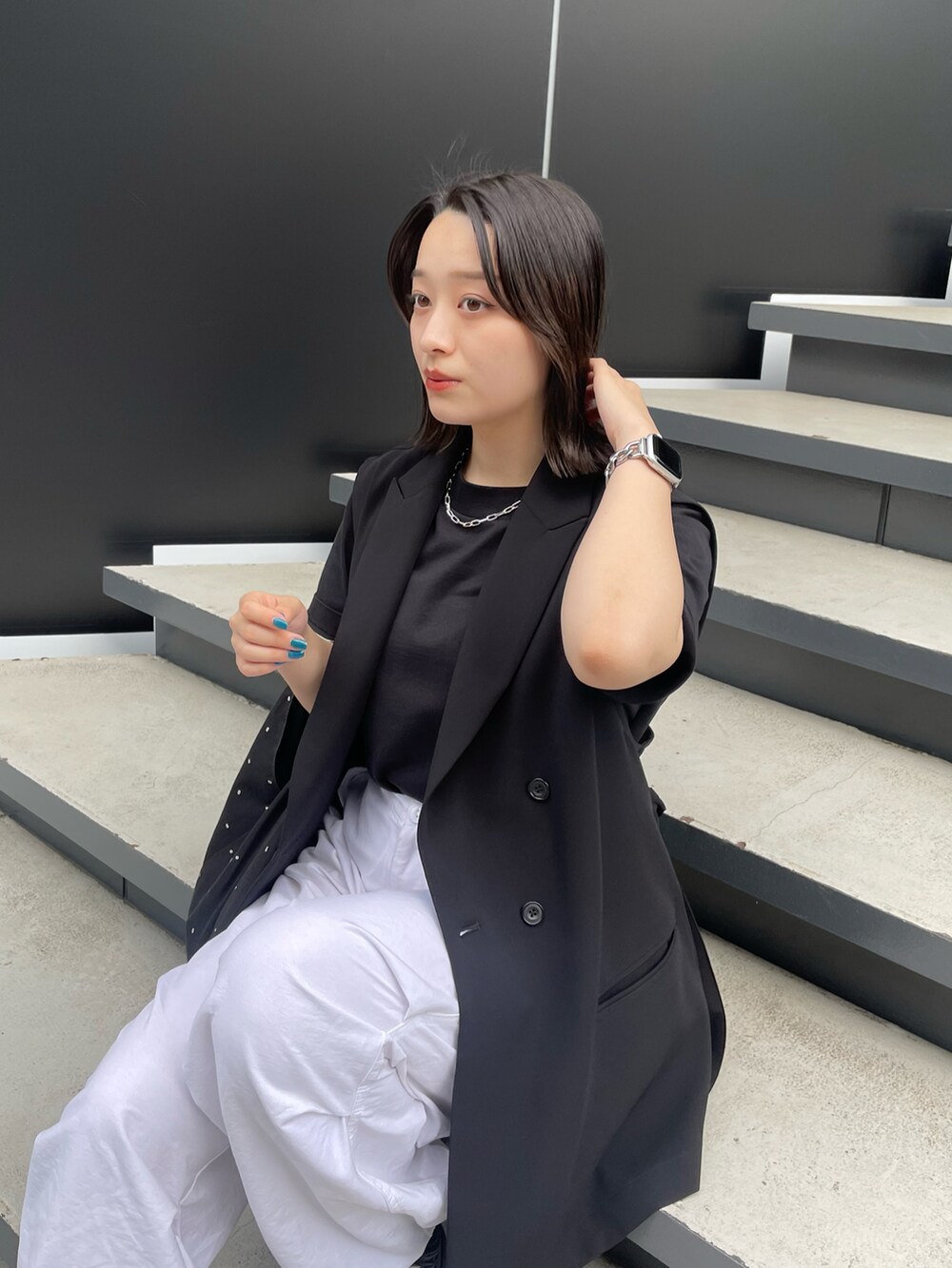 ブラック系のベスト、ホワイト系のその他パンツを着用したレディースの春コーディネートの2枚目の写真