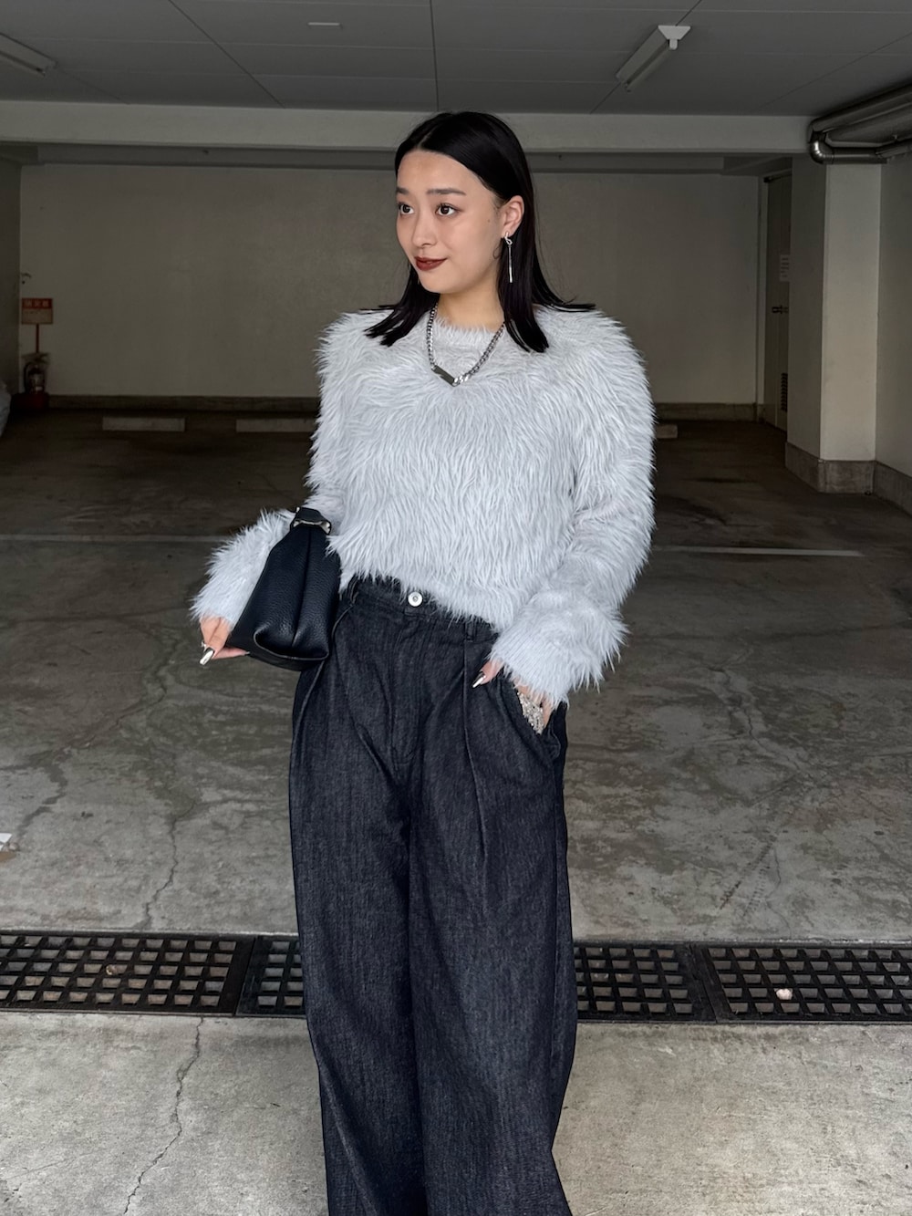 ブラック系のデニムパンツ、ブラック系のトートバッグ、グレー系のニット/セーターを着用したレディースの秋コーディネートの2枚目の写真