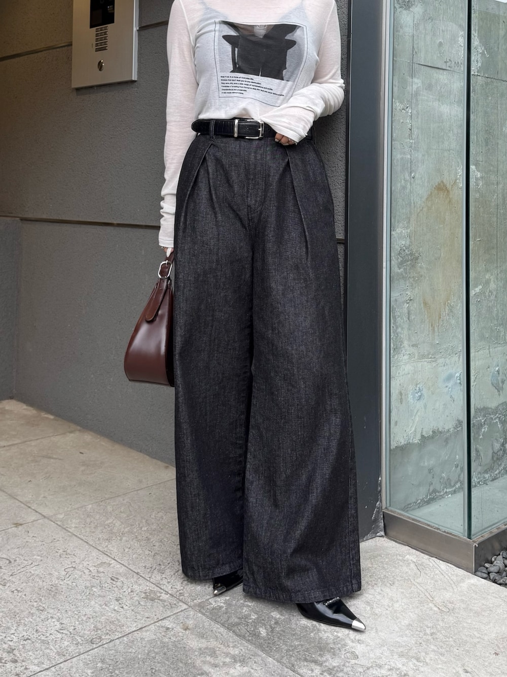 ブラック系のデニムパンツ、ホワイト系のTシャツ/カットソー、ブラウン系のハンドバッグを着用したレディースの秋コーディネートの5枚目の写真