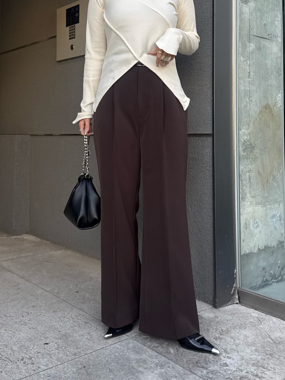 ホワイト系のTシャツ/カットソー、ブラウン系のスラックス、ブラック系のトートバッグを着用したレディースの冬コーディネートの5枚目の写真