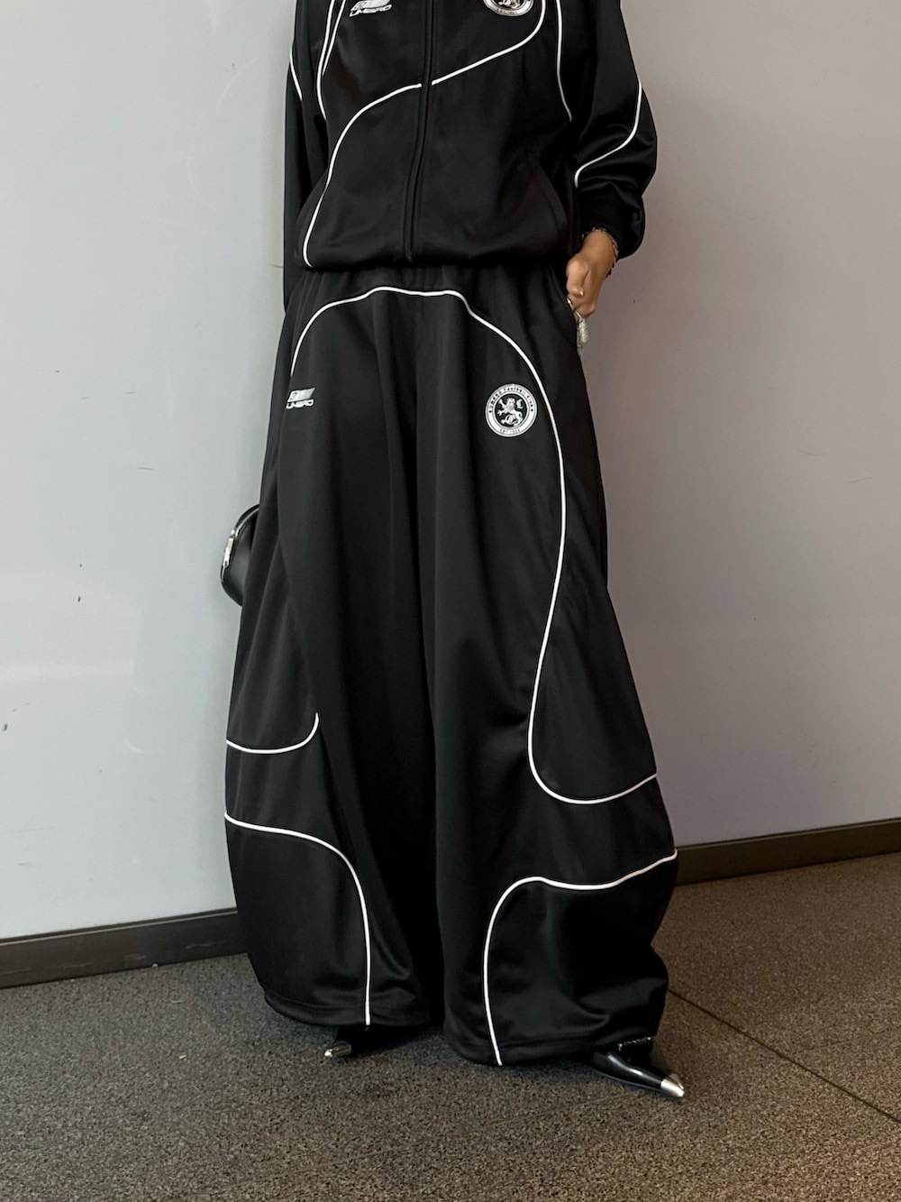 ブラック系のブルゾン、ブラック系のその他パンツ、ブラック系のショルダーバッグを着用したレディースの冬コーディネートの6枚目の写真