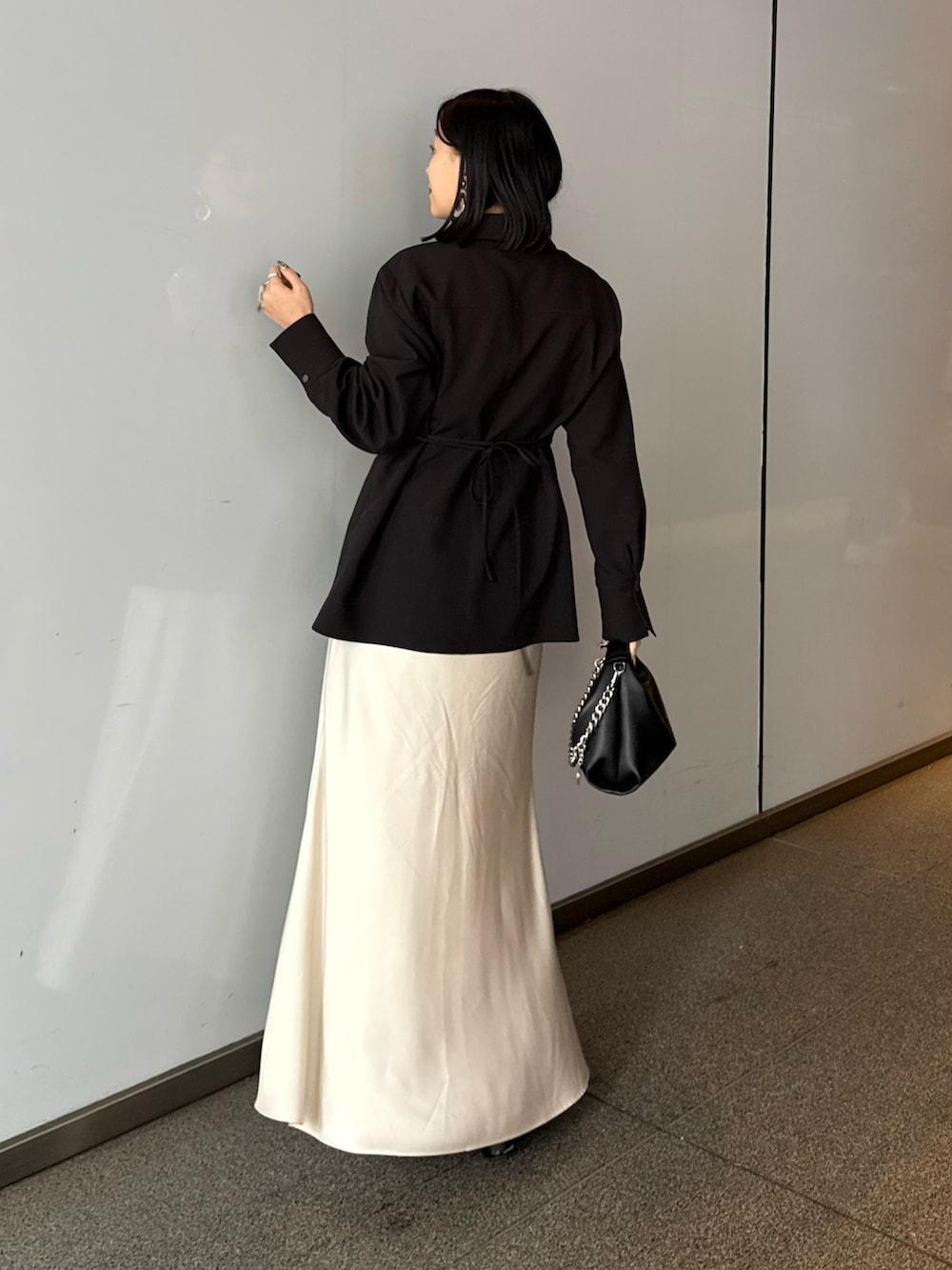 ブラック系のシャツ/ブラウス、ホワイト系のスカート、ブラック系のトートバッグを着用したレディースの春コーディネートの2枚目の写真