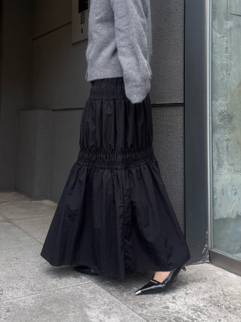 グレー系のカーディガン/ボレロ、ブラック系のスカート、ブラック系のトートバッグを着用したレディースの夏コーディネートの6枚目の写真