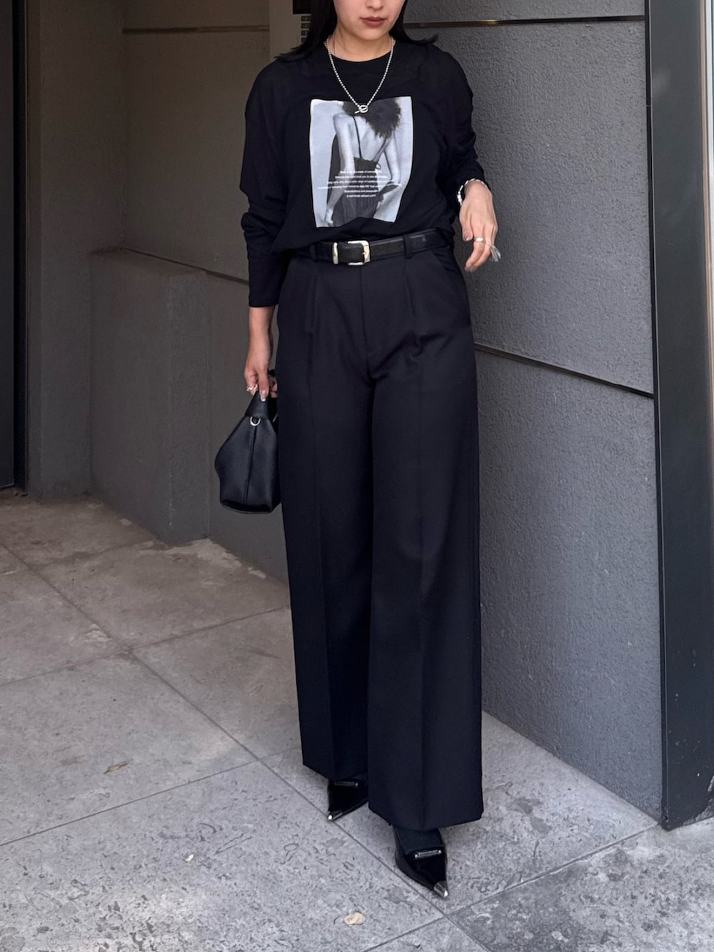 ブラック系のTシャツ/カットソー、ブラック系のスラックス、ブラック系のショルダーバッグを着用したレディースの夏コーディネートの2枚目の写真