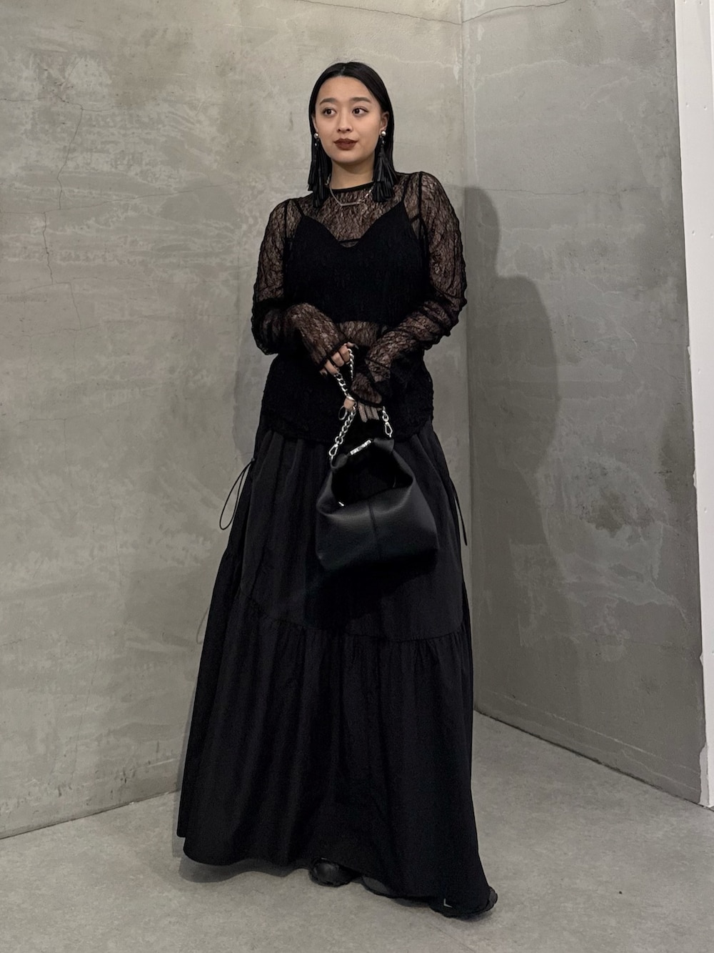 ブラック系のTシャツ/カットソー、ブラック系のスカート、ブラック系のトートバッグを着用したレディースの冬コーディネートの2枚目の写真