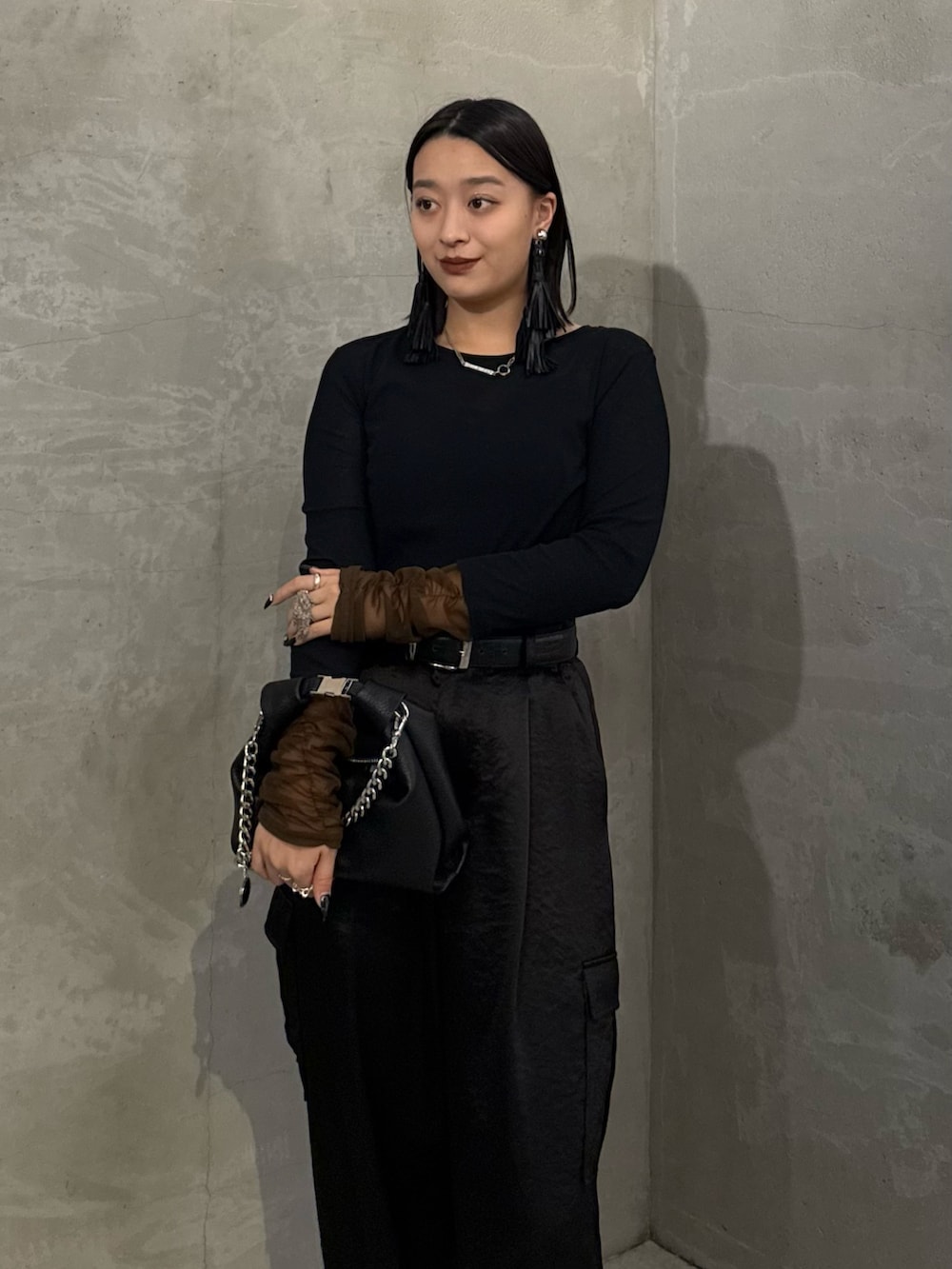 ブラック系のTシャツ/カットソー、ブラック系のカーゴパンツ、ブラック系のトートバッグを着用したレディースの冬コーディネートの4枚目の写真