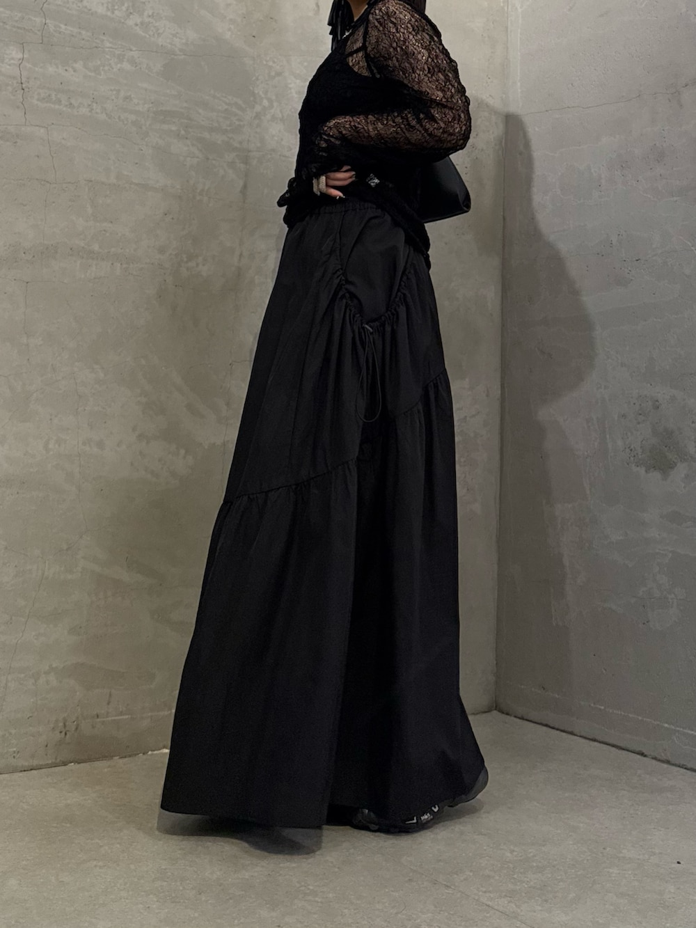 ブラック系のTシャツ/カットソー、ブラック系のスカート、ブラック系のトートバッグを着用したレディースの冬コーディネートの7枚目の写真