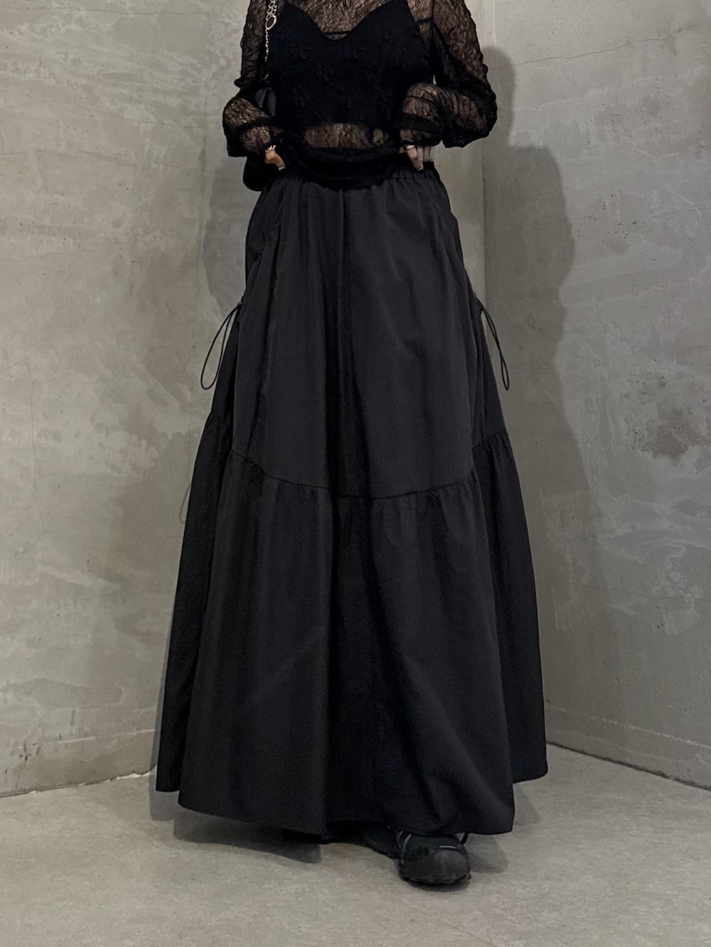 ブラック系のTシャツ/カットソー、ブラック系のスカート、ブラック系のトートバッグを着用したレディースの冬コーディネートの6枚目の写真