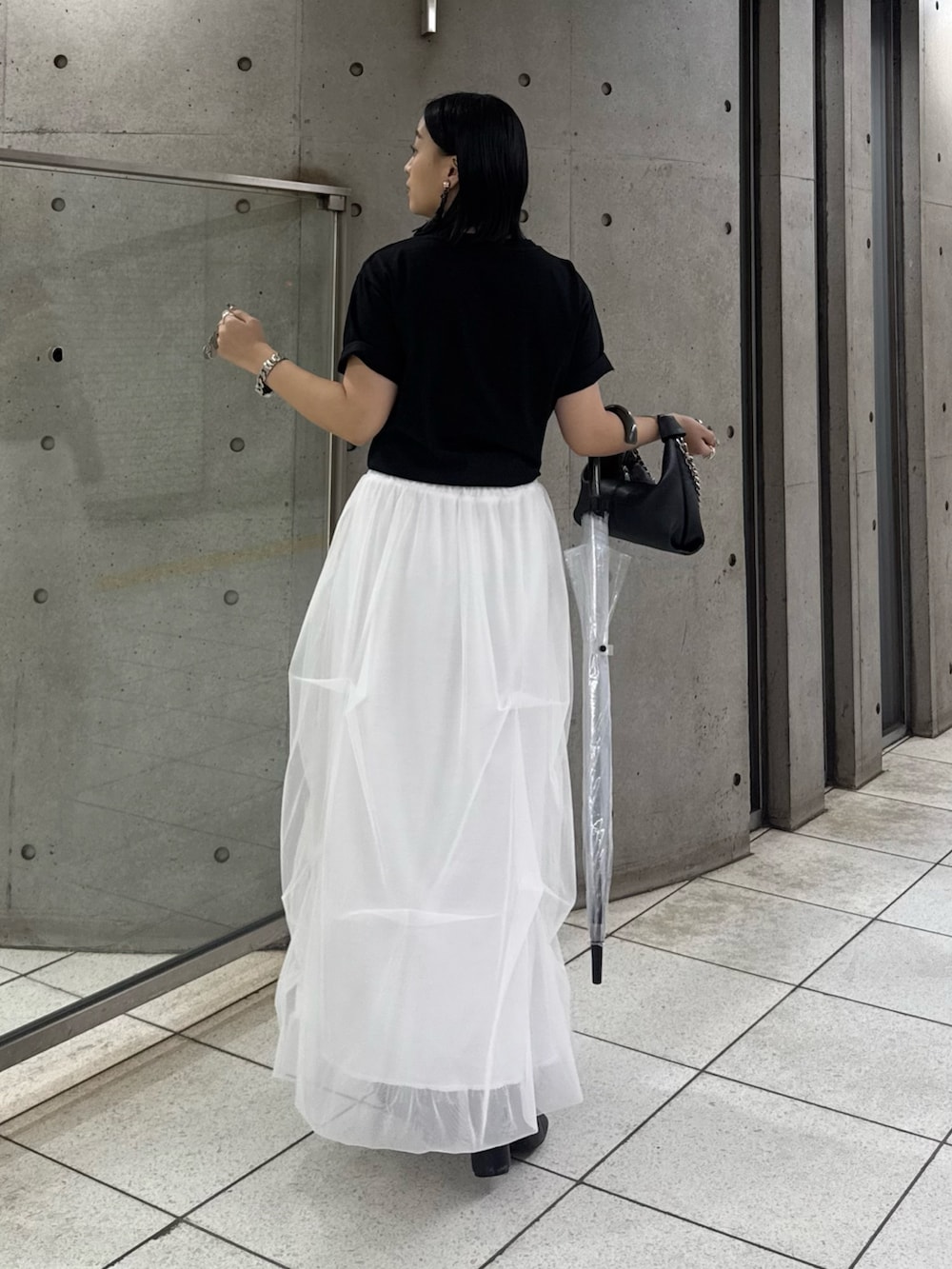 ブラック系のTシャツ/カットソー、ホワイト系のスカート、ブラック系のトートバッグを着用したレディースの春コーディネートの2枚目の写真