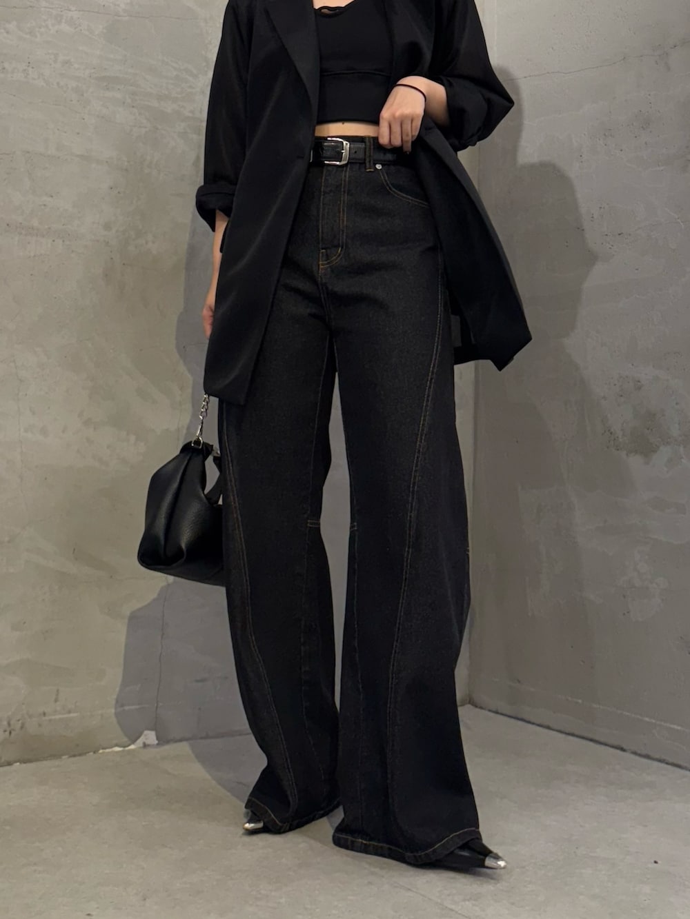 ブラック系のテーラードジャケット、ブラック系のデニムパンツ、ブラック系のトートバッグを着用したレディースの冬コーディネートの7枚目の写真