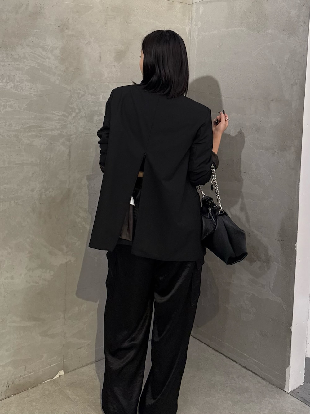 ブラック系のテーラードジャケット、ブラック系のカーゴパンツ、ブラック系のトートバッグを着用したレディースの冬コーディネートの5枚目の写真