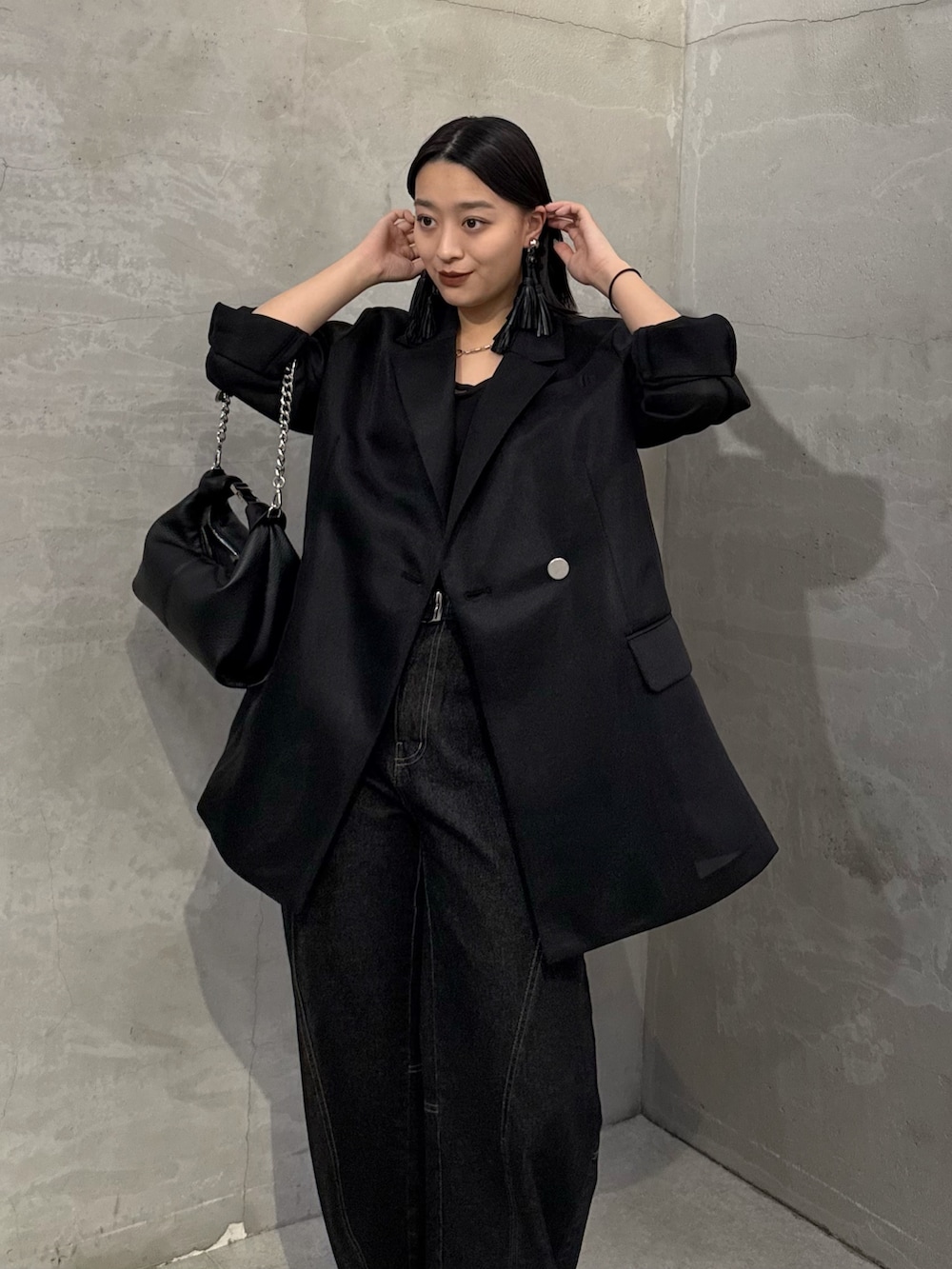 ブラック系のテーラードジャケット、ブラック系のデニムパンツ、ブラック系のトートバッグを着用したレディースの冬コーディネートの5枚目の写真