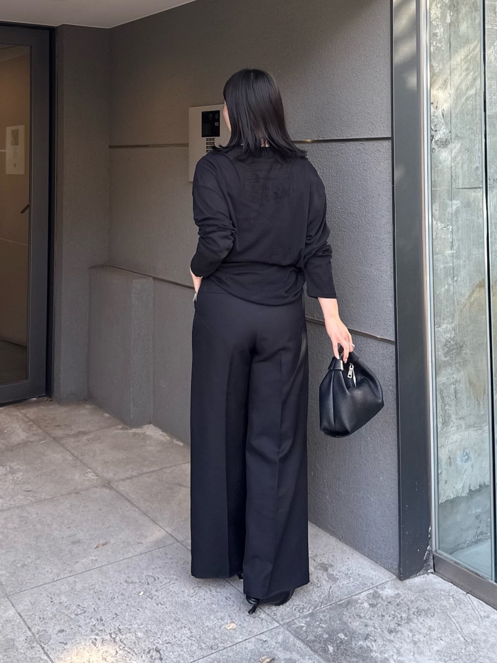 ブラック系のTシャツ/カットソー、ブラック系のスラックス、ブラック系のショルダーバッグを着用したレディースの夏コーディネートの3枚目の写真