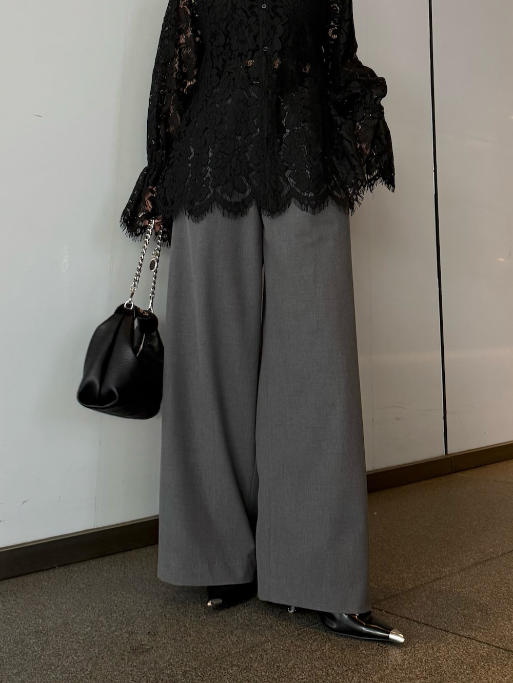 ブラック系のシャツ/ブラウス、グレー系のスラックス、ブラック系のトートバッグを着用したレディースの春コーディネートの5枚目の写真