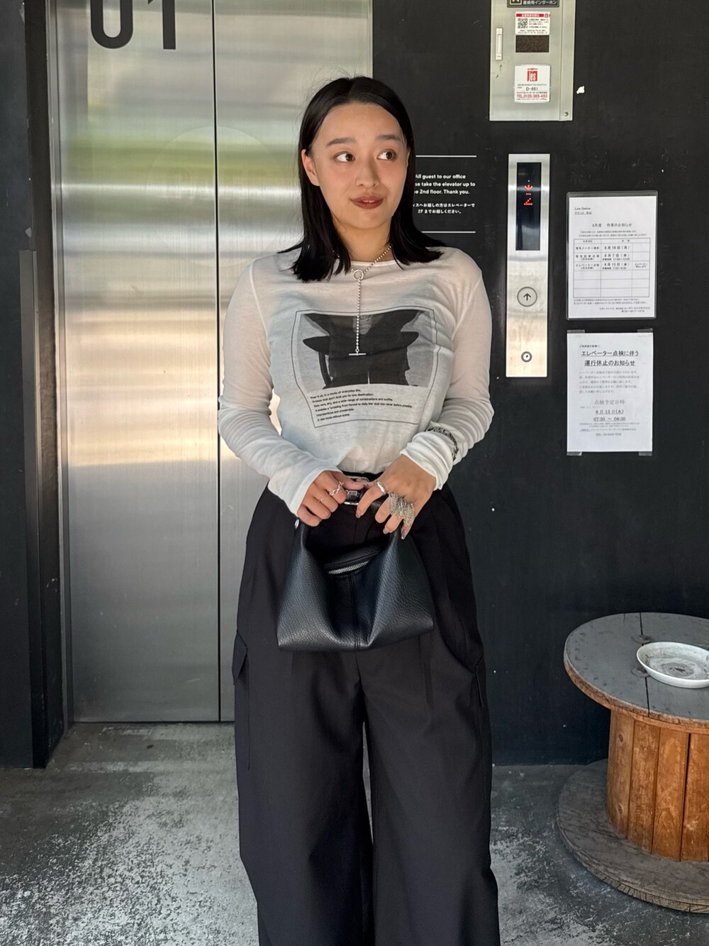 ホワイト系のTシャツ/カットソー、ブラック系のカーゴパンツ、ブラック系のショルダーバッグを着用したレディースの夏コーディネートの3枚目の写真