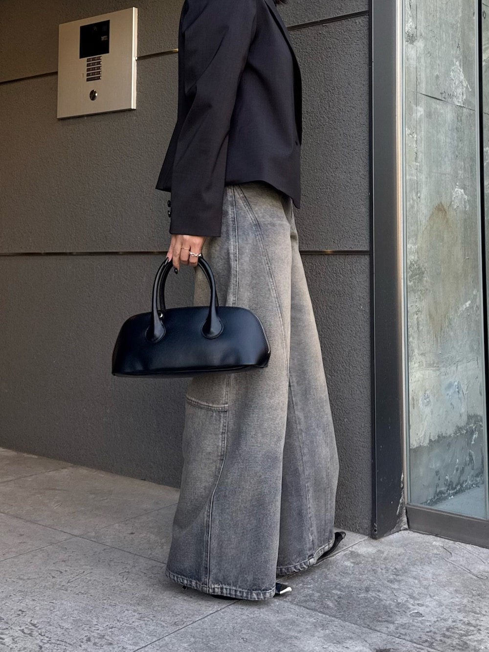 ブラック系のテーラードジャケット、ブルー系のデニムパンツ、ブラック系のショルダーバッグを着用したレディースの冬コーディネートの7枚目の写真