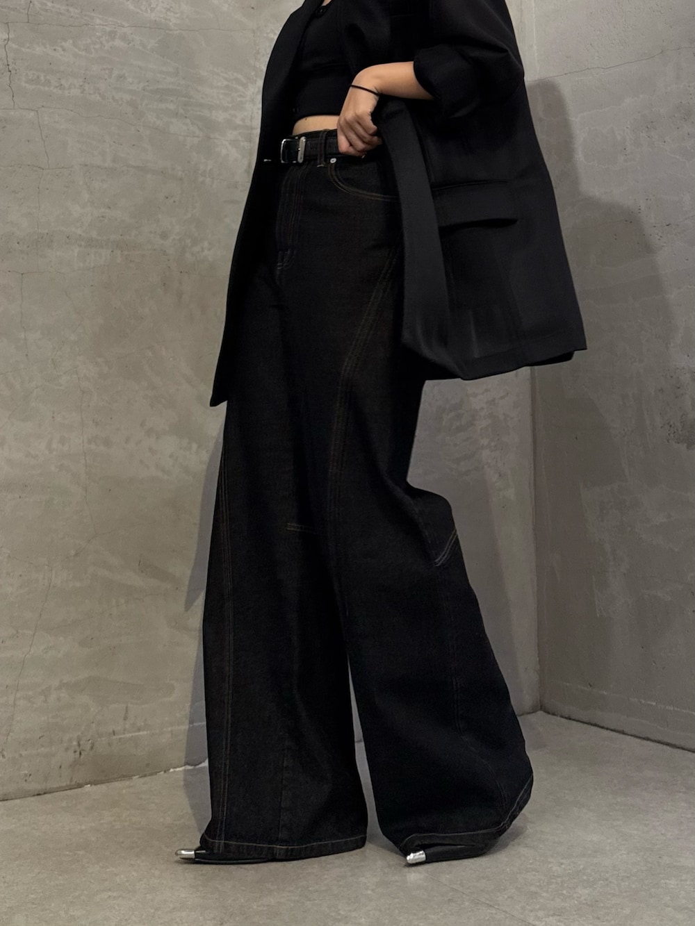 ブラック系のテーラードジャケット、ブラック系のデニムパンツ、ブラック系のトートバッグを着用したレディースの冬コーディネートの8枚目の写真