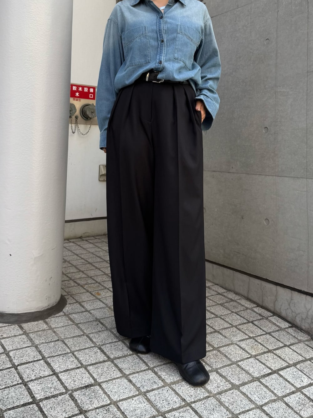 ブルー系のシャツ/ブラウス、ブラック系のスラックス、ブラック系のブーツを着用したレディースの秋コーディネートの5枚目の写真