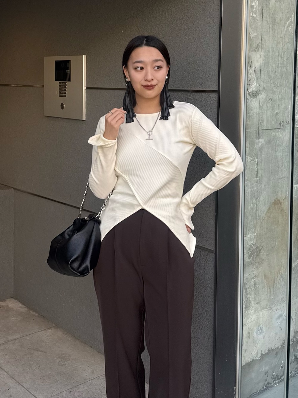 ホワイト系のTシャツ/カットソー、ブラウン系のスラックス、ブラック系のトートバッグを着用したレディースの冬コーディネートの3枚目の写真